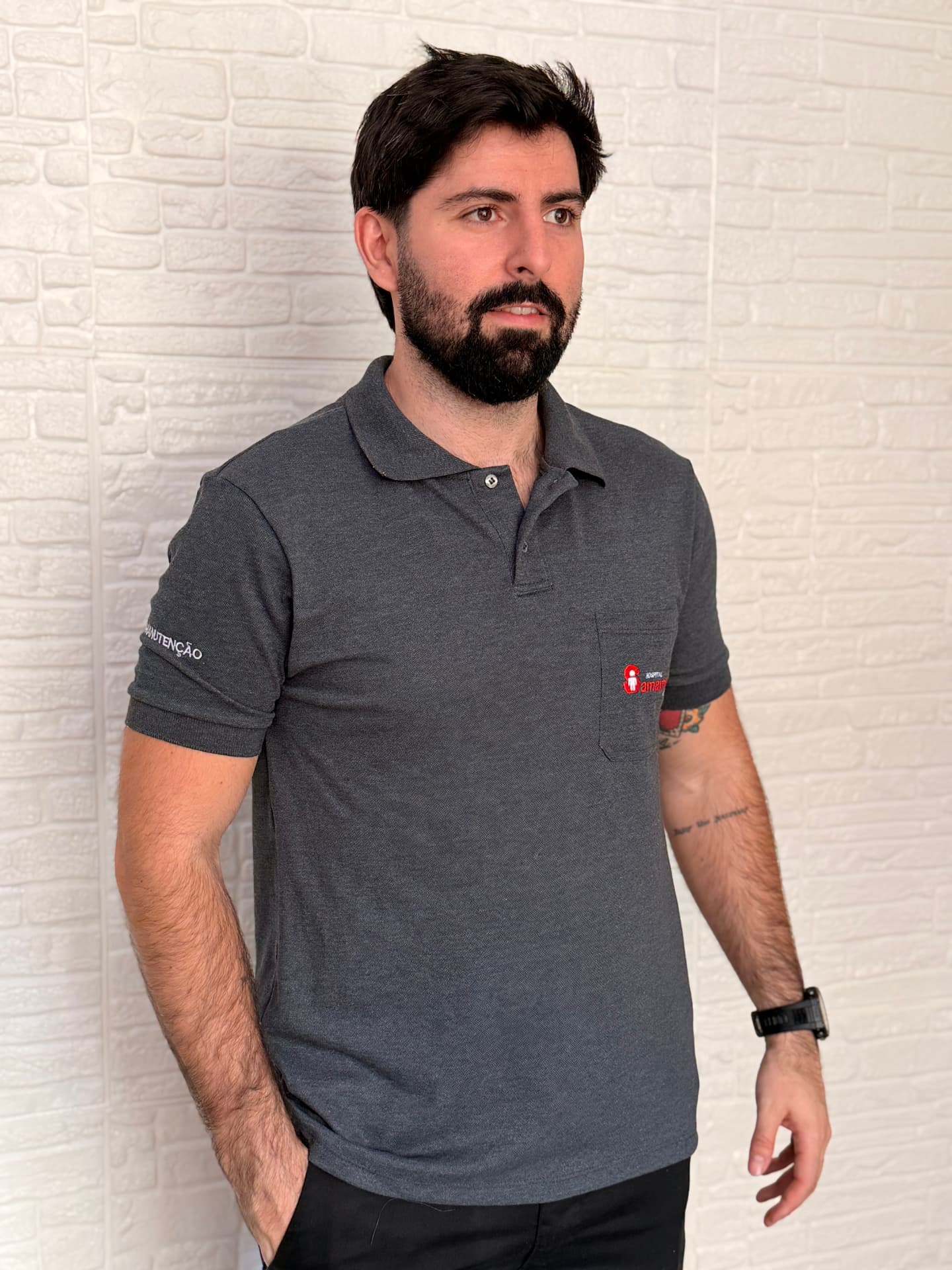 Colaborador vestindo polo cinza chumbo personalizada com bordado no bolso e na manga